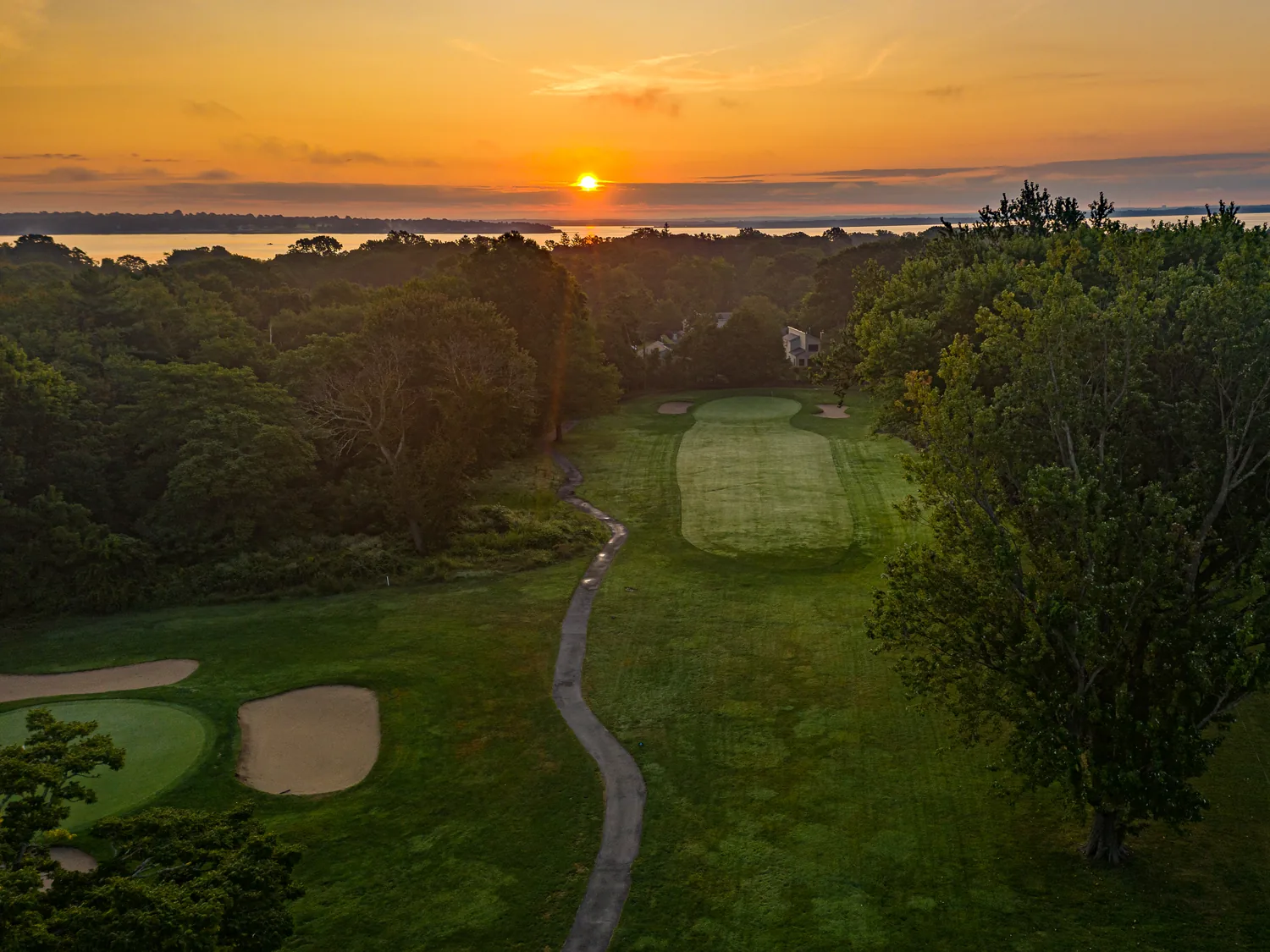Sunset over Narragansett Bay with the Potowomut Golf Club course in the foreground